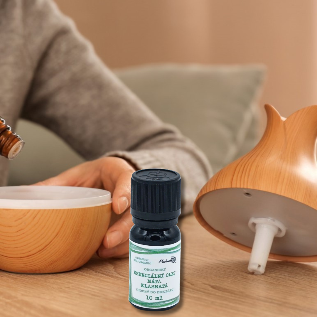 Organic mint essential oil for diffusers (10 ml) from Medarek placed in front of a wooden aroma diffuser being filled